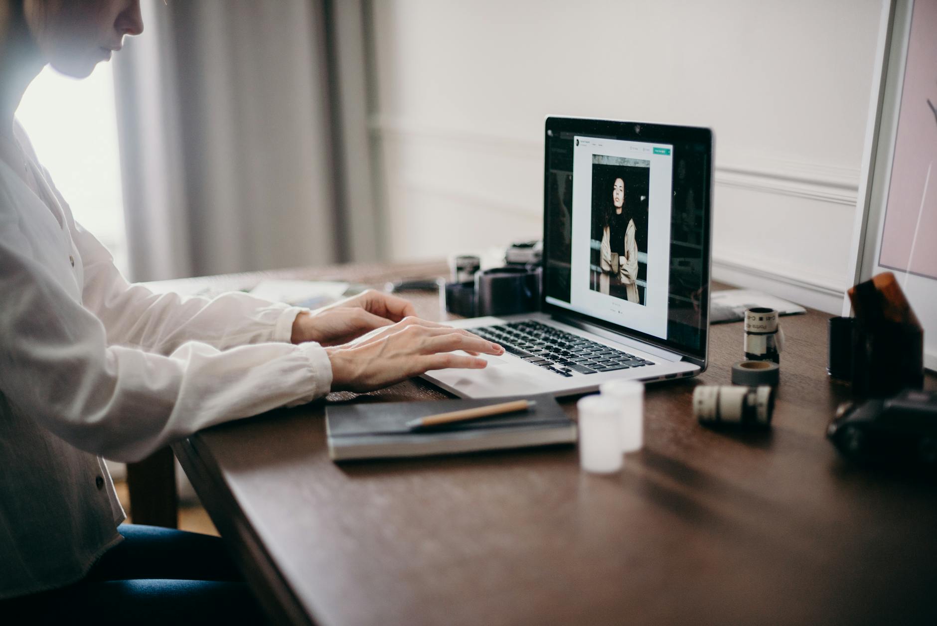 selective focus photography of woman using macbook pro ; things to outsource as a photographer