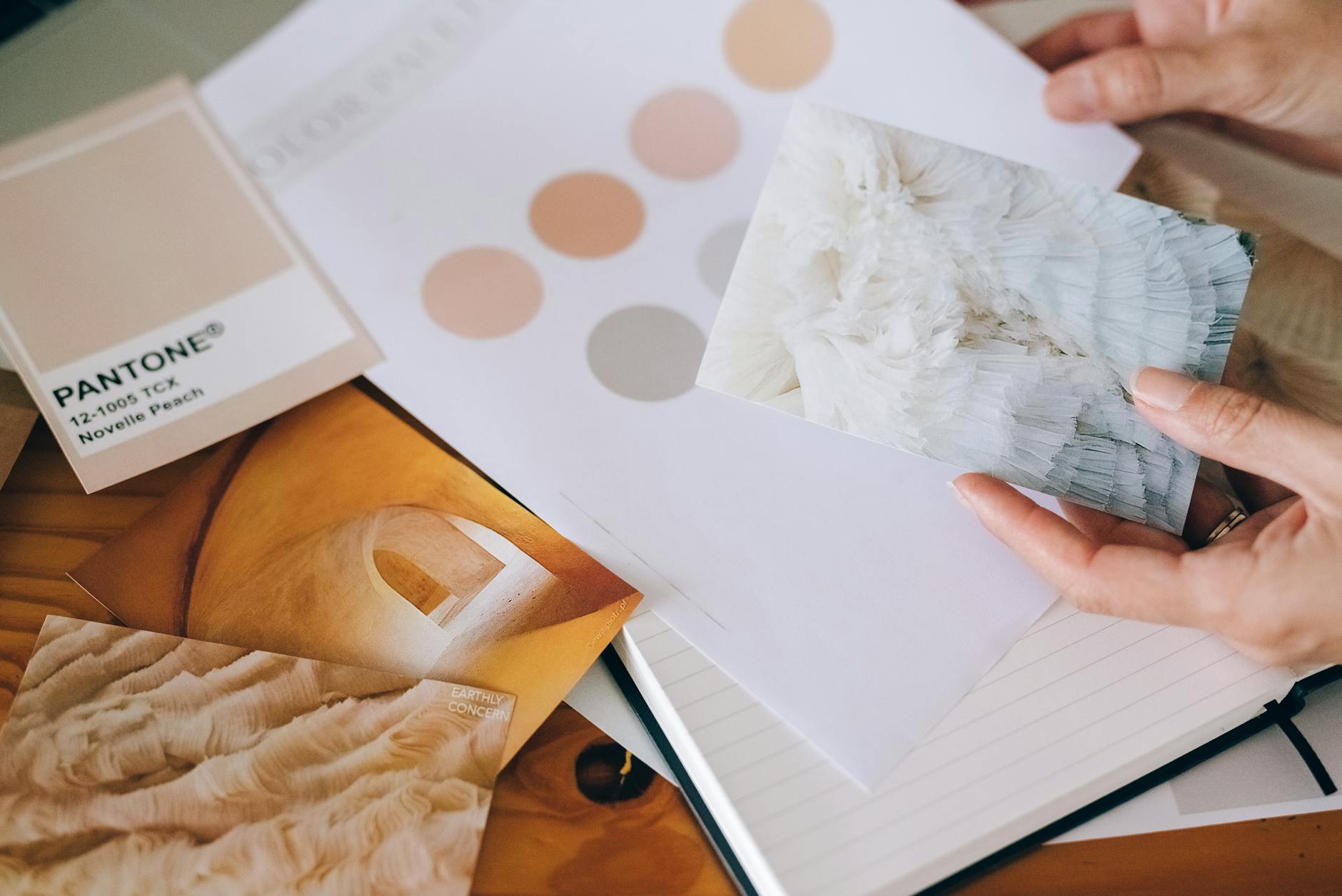 hands holding card over paper and notebook